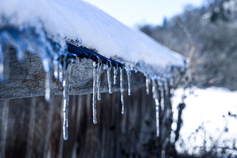 Icicles hanging from a snow-covered roof edge