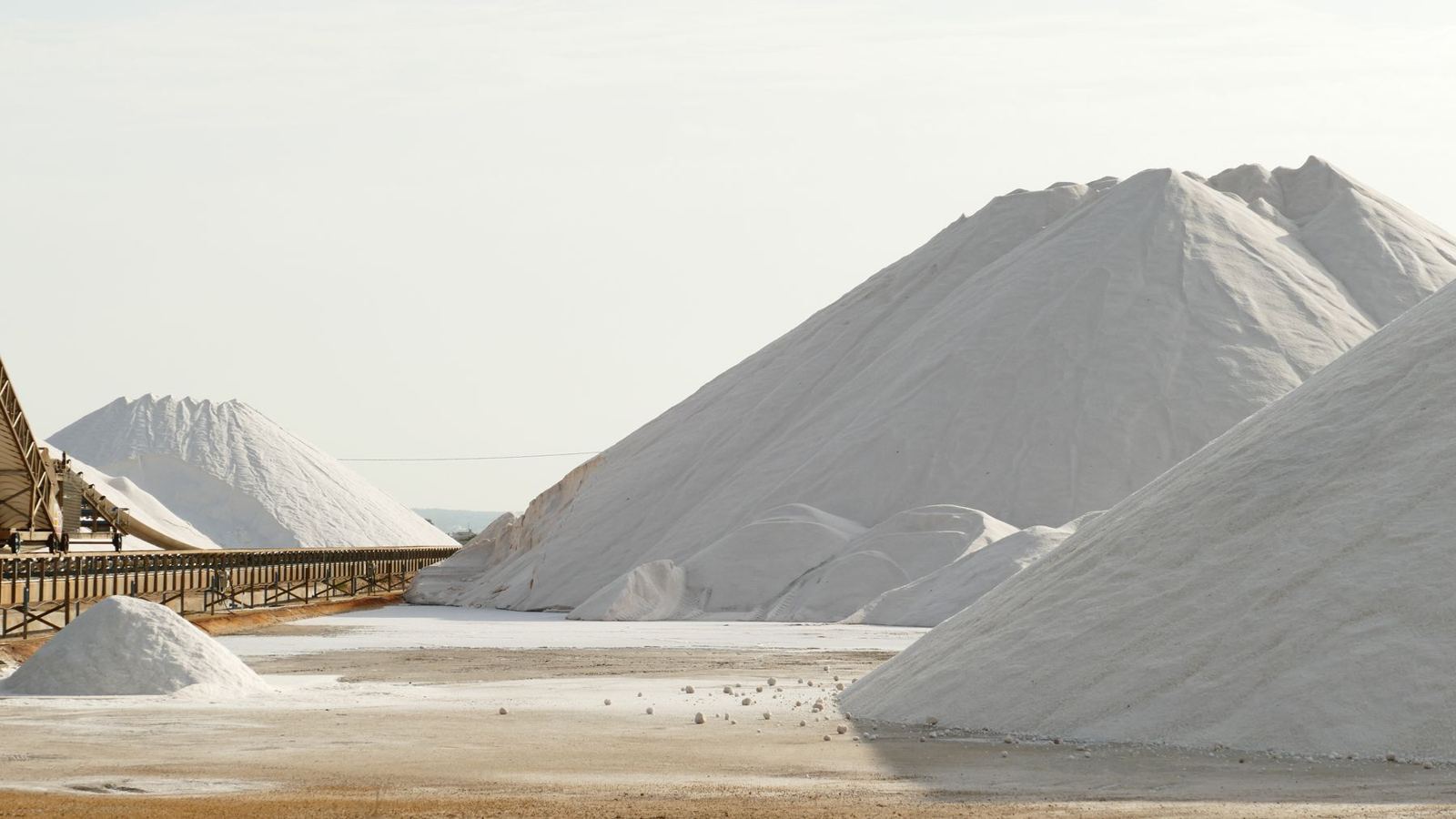 Large white salt stockpiles at a bulk salt facility